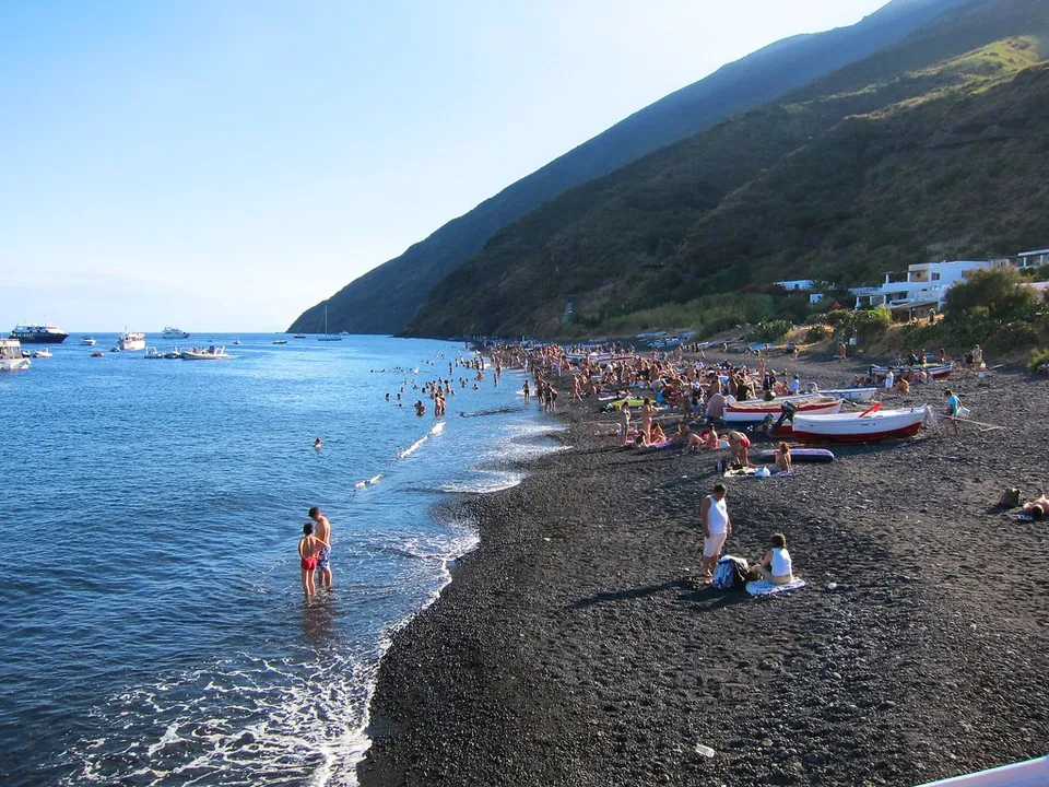 Svart sandstrand på Stromboli med badgäster